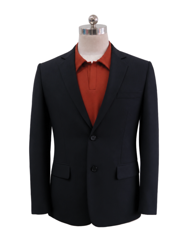 Men's classic two-button corporate suit blazer in dark charcoal black featuring tailored notch lapels and waist flap pockets, styled over a burnt orange inner polo shirt, designed by Modoleen Singapore for contemporary office wear programs.