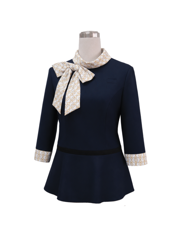 Women's dark navy blue corporate tunic blouse featuring a flared peplum hem, 3/4 sleeves with white and gold chain-patterned cuffs, and a matching high-neck collar bow tie designed by Modoleen Singapore for office and hospitality uniforms.