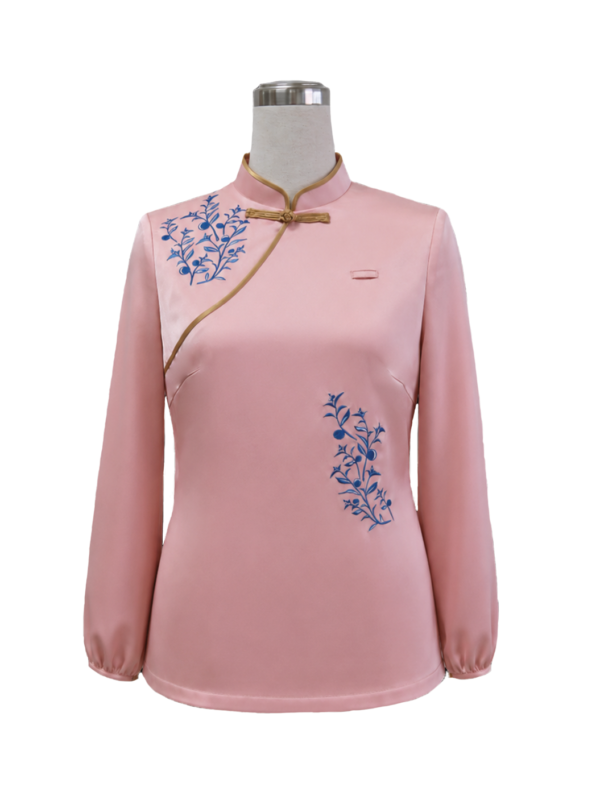 Women's pink satin chinese - east asian cheongsam uniform top featuring a mandarin collar with gold frog button closures, gold piping trim, and blue floral branch embroidery, designed by Modoleen Singapore for luxury hospitality, fine dining, and corporate uniform programs.